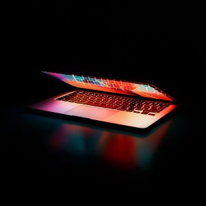 Image of a laptop partially open and lit up.